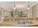 Kitchen featuring granite countertops, stainless steel sink, and a view of the living area at 6214 45Th E Ln, Bradenton, FL 34203