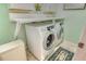 Laundry area with front loading washer and dryer and built-in folding table and cabinet at 6214 45Th E Ln, Bradenton, FL 34203