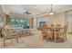 Comfortable living room with tile floors, a ceiling fan, and sliding doors to the screened patio at 6214 45Th E Ln, Bradenton, FL 34203