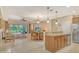 Open-concept living room with tile flooring, dining area, and a kitchen island with bar seating at 6214 45Th E Ln, Bradenton, FL 34203