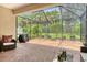 View of the backyard from the screened patio with outdoor furniture and a barbecue grill at 6214 45Th E Ln, Bradenton, FL 34203
