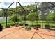 Screened patio with patterned concrete flooring and a relaxing outdoor area with lush tropical landscape at 6214 45Th E Ln, Bradenton, FL 34203