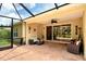 Inviting screened-in patio with comfortable seating, ceiling fan, and decorative elements, perfect for outdoor relaxation at 6214 45Th E Ln, Bradenton, FL 34203