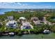 Waterfront homes with private docks nestled in lush greenery overlooking the bay in a sunny, tropical locale at 663 Penfield St, Longboat Key, FL 34228