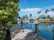 Backyard canal view with wood dock and lush greenery, reflecting blue sky and nearby homes at 663 Penfield St, Longboat Key, FL 34228