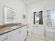 Bright bathroom features granite countertop, lighted mirror, and a glass-enclosed shower near the window at 663 Penfield St, Longboat Key, FL 34228