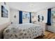 A bright bedroom features a large bed with patterned covers and windows with blue curtains at 663 Penfield St, Longboat Key, FL 34228