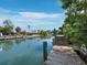 Picturesque canal view with wooden dock, blue water, and waterfront homes in a lush, tropical setting at 663 Penfield St, Longboat Key, FL 34228