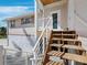 Elevated coastal home featuring wooden stairs leading to the entrance and shuttered windows at 663 Penfield St, Longboat Key, FL 34228