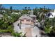 Coastal home featuring a two-car garage, shell driveway, lush landscaping, and a charming exterior design at 663 Penfield St, Longboat Key, FL 34228