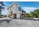 Modern elevated coastal home with shell landscaping, palm trees, and a deck at 663 Penfield St, Longboat Key, FL 34228