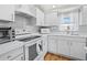 Modern kitchen with stainless appliances, white cabinets, and white countertop near a window at 663 Penfield St, Longboat Key, FL 34228