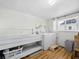 Bright laundry room with a washer, dryer, utility sink, and storage shelves at 663 Penfield St, Longboat Key, FL 34228