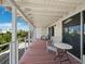 A covered porch has chairs and a table, with access to the exterior and interior through glass doors at 663 Penfield St, Longboat Key, FL 34228