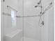 This remodeled shower features multiple shower heads, a built-in bench, and bright white tile at 663 Penfield St, Longboat Key, FL 34228