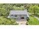 Aerial view of a two-story home with a patio, surrounded by a well-manicured lawn and mature trees at 6633 Old Ranch Rd, Sarasota, FL 34241
