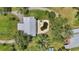 Aerial view of the backyard featuring a unique kidney-shaped pool with surrounding greenery and the roof of an adjacent structure at 6633 Old Ranch Rd, Sarasota, FL 34241