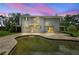 View of the back of the house with a pool and a large yard at dusk at 6633 Old Ranch Rd, Sarasota, FL 34241