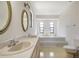 Bright bathroom with double vanity, mirrors, and a tub at 6633 Old Ranch Rd, Sarasota, FL 34241