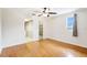 A well lit bedroom with wood floors, ceiling fan, and a view to a bathroom and walk-in closet at 6633 Old Ranch Rd, Sarasota, FL 34241