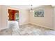 Dining room with tile flooring, natural light, and open layout to a living space with wooden walls at 6633 Old Ranch Rd, Sarasota, FL 34241