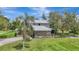 Two-story home with stone facade, covered porch, well-manicured lawn, and mature trees at 6633 Old Ranch Rd, Sarasota, FL 34241