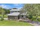 Two-story home with stone facade, covered porch, manicured lawn, mature trees and circular window at 6633 Old Ranch Rd, Sarasota, FL 34241