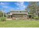 Two-story home with a stone exterior accent, featuring a covered porch on a well-maintained lawn at 6633 Old Ranch Rd, Sarasota, FL 34241