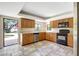 A well-lit kitchen with wooden cabinets and modern appliances, next to open doorway to backyard patio at 6633 Old Ranch Rd, Sarasota, FL 34241