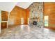Open living room with a stone fireplace and wood paneled walls at 6633 Old Ranch Rd, Sarasota, FL 34241