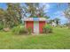 Charming red shed surrounded by tall grass and mature trees at 6633 Old Ranch Rd, Sarasota, FL 34241