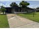 Quaint one-story home featuring a covered carport, a large front yard and mature landscaping at 6707 Northampton Pl, Bradenton, FL 34207