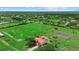 Expansive acreage with lush lawns, mature trees, a charming home with a red roof, and a tranquil pond at 6805 225Th E St, Bradenton, FL 34211