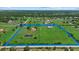 Aerial view of a sprawling estate featuring a home, pond, outbuilding, and lush green pastures at 6805 225Th E St, Bradenton, FL 34211