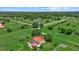 Aerial view of a charming home with a red roof, an outdoor patio and a lush, green lawn at 6805 225Th E St, Bradenton, FL 34211
