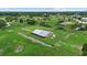 Aerial view of a well-kept barn on a lush, green, grassy property with mature trees and fencing at 6805 225Th E St, Bradenton, FL 34211