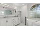 Elegant bathroom with arch window, marble countertops, modern fixtures, and free-standing tub at 6805 225Th E St, Bradenton, FL 34211