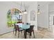 Bright dining room with a glass table, modern lighting and a large arch window offering a view of the greenery at 6805 225Th E St, Bradenton, FL 34211