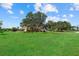 A lush green lawn surrounds a home with mature trees and landscaping at 6805 225Th E St, Bradenton, FL 34211