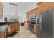 Kitchen featuring wood cabinets, granite countertops, stainless appliances, and tile floors at 6805 225Th E St, Bradenton, FL 34211