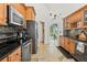 Modern kitchen with stainless steel appliances, stone countertops, and wooden cabinets with a glimpse of dining room at 6805 225Th E St, Bradenton, FL 34211