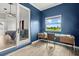 Home office with dark blue walls, light wood floors, a desk by the window and doorway to a bedroom at 6805 225Th E St, Bradenton, FL 34211