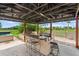 Covered outdoor kitchen with a bar, BBQ, and a view of the backyard at 6805 225Th E St, Bradenton, FL 34211