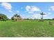 Large, manicured yard with lush grass, palm trees and beautiful landscaping around the home at 6805 225Th E St, Bradenton, FL 34211