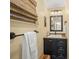 Bathroom with a rustic vanity, a mirror, a towel rack, and a window with a bamboo blind at 7343 Palomino Trl, Sarasota, FL 34241