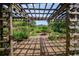 Charming garden featuring a wooden pergola, raised planting beds, and a variety of shrubs and flowers at 7343 Palomino Trl, Sarasota, FL 34241