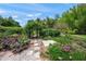 Enchanting garden pathway with stone pavers, archway, and diverse plantings, creating a serene outdoor escape at 7343 Palomino Trl, Sarasota, FL 34241