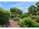 Tranquil garden retreat featuring raised planters, lush greenery, seating areas, and a variety of plants at 7343 Palomino Trl, Sarasota, FL 34241