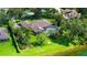 Aerial view showcases the home's screened pool, lush landscaping, and proximity to a tranquil lake at 7426 Weeping Willow Blvd, Sarasota, FL 34241