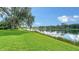 Expansive green lawn gently sloping towards the serene lake provides a picturesque and tranquil setting at 7426 Weeping Willow Blvd, Sarasota, FL 34241